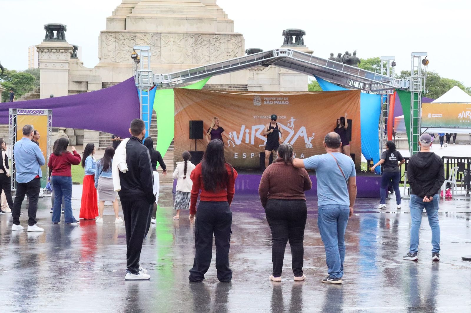 Público dançando em frente ao palco mesmo com chuva